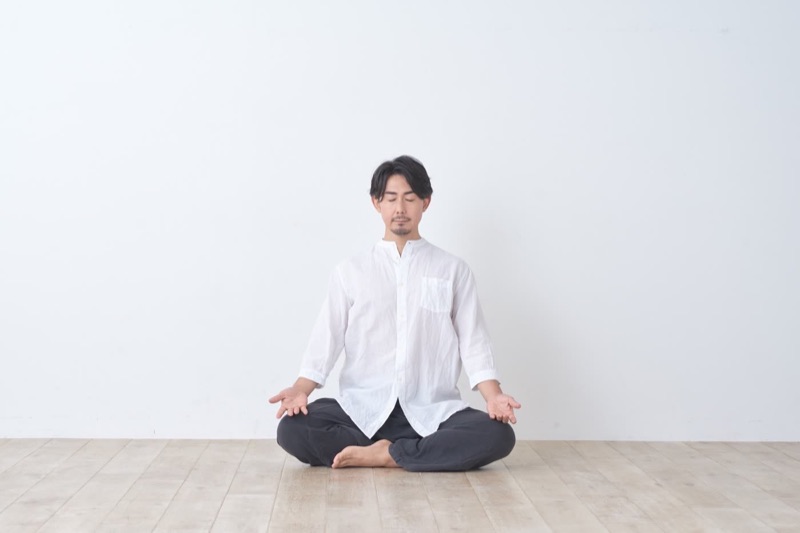 白い壁の前で瞑想する吉田昌生